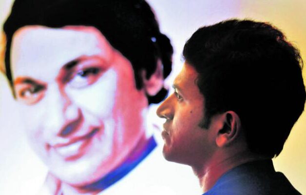 PUNEETH RAJAKUMAR WITH PORTRAIT OF DR RAJAKUMAR